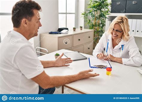 Middle Age Man And Woman Doctor And Patient Having Medical Consultation At Clinic Stock Image