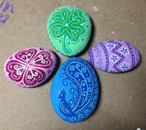 Four Painted Rocks Sitting On Top Of A Table