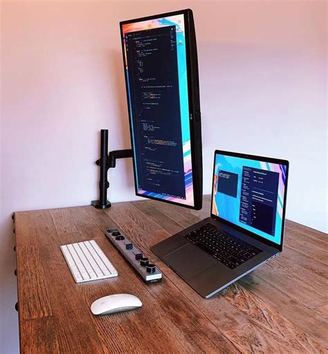 A Laptop Computer Sitting On Top Of A Wooden Desk Next To A Monitor And