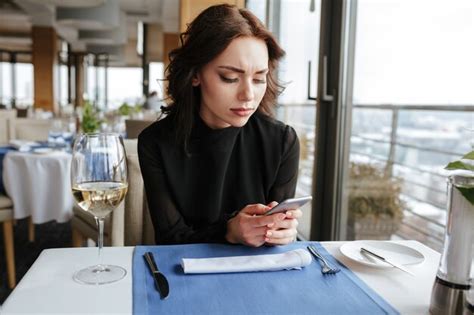 Mujer En Restaurante Escribiendo Mensajes En El Teléfono Foto Premium