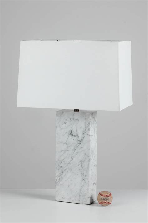 A Marble Lamp With A White Shade On It