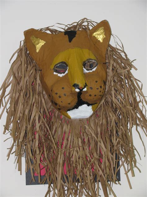 Student dips newspaper strips into mixture, wiping any extra off into the container with index finger and thumb. 3rd grade paper mache lion mask; lesson designed by art ...