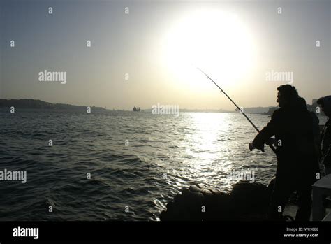 Silhouette Man Fishing In Sea During Sunset Stock Photo Alamy