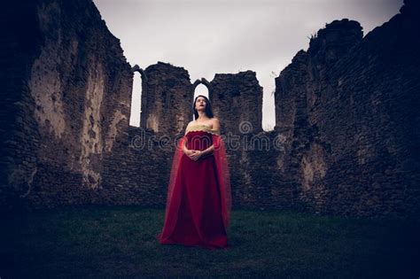 Caucasian Woman Wearing A Medieval Red Dress Posing Against Historical