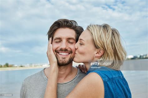 Happy Young Couple Kissing On The Beach High Res Stock Photo Getty Images