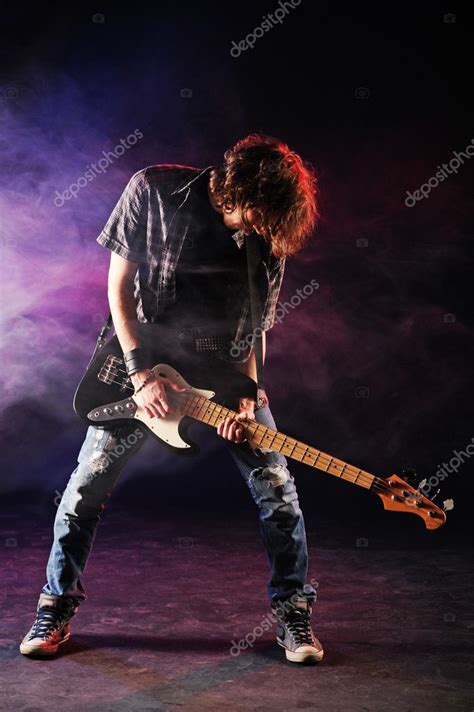 Rock Bassist Plays His Bass On A Dark Background Stock Photo By