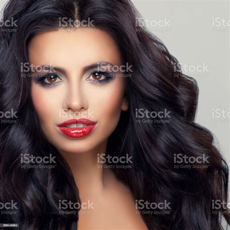 perfect brunette woman model with healthy curly hair and makeup beautiful female face stock