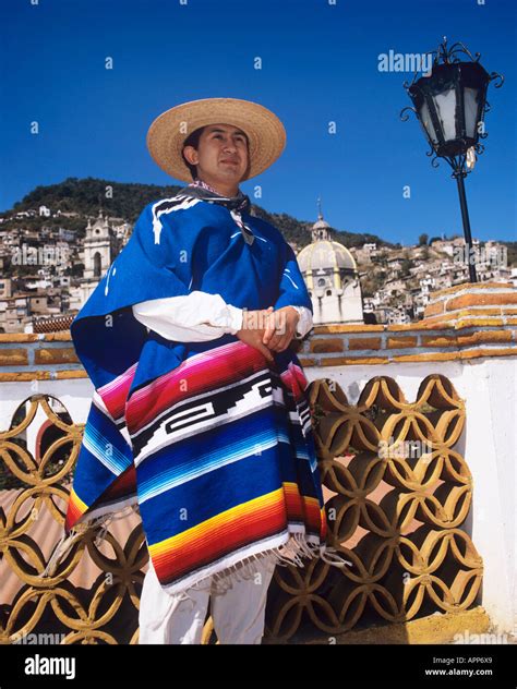 Local Mexican In Traditional Sombrero And Poncho Standing Next To A