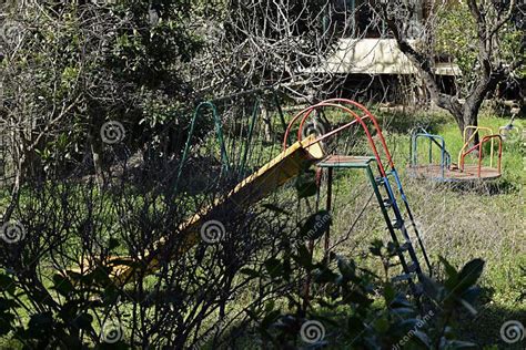 Swings And Slides In Abandoned Overgrown Playground Stock Image Image