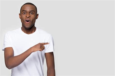 Surprised Funny African Man Pointing Aside Looking At Camera Stock