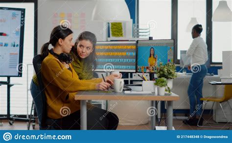 Confident Women Photo Editors Sitting At Workplace In Creative Studio