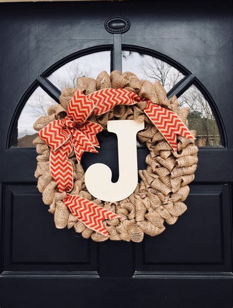A Wreath With The Letter J On It Is Hanging In Front Of A Black Door