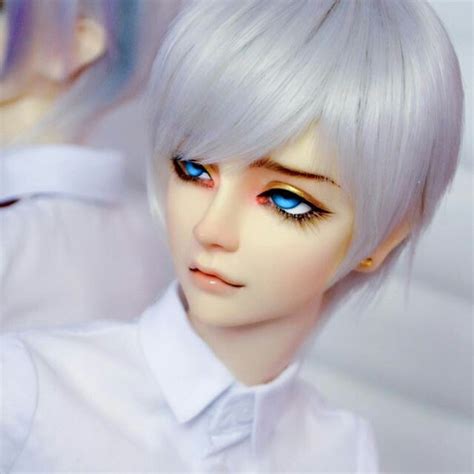 A Doll With White Hair And Blue Eyes Is Posed For The Camera In Front