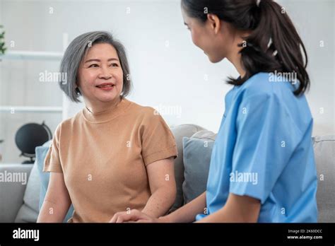 A contented senior woman visited by her personal caregiver and hold