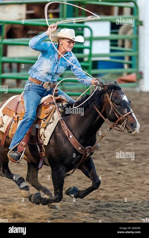 Rodeo Cowgirl On Horseback Competing In Calf Roping Or Tie Down Roping