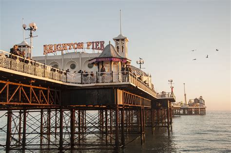 A Pier With People Standing On It Next To The Ocean