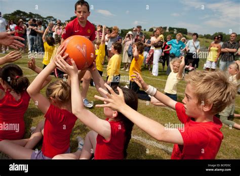 Teams Of Young Children Competing At Passing A Ball Backwards Over