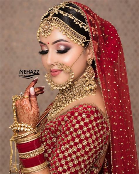 a woman in a red and gold bridal outfit with her hands on her face