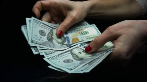 Macro shot female hands holding cash money against black background ...