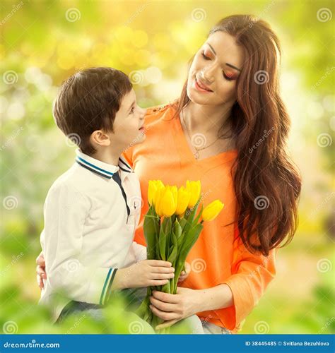 El Hijo Que Abraza A Su Madre Y Le Da Las Flores Foto De Archivo Libre