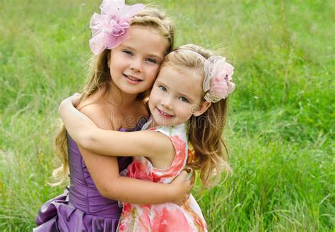 portret van twee die leuke meisjes omhelzen stock foto image of openlucht gras 27088560