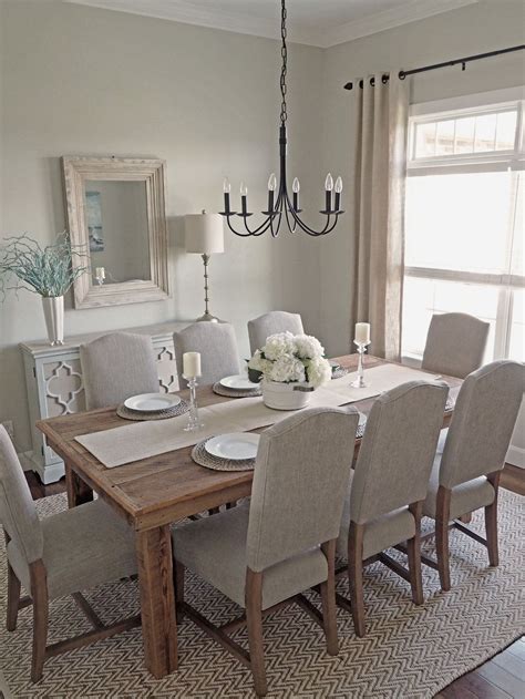 The Dining Room Table Is Set With White Flowers And Place Settings For