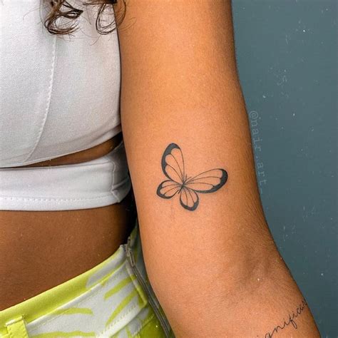 A Womans Arm With A Butterfly Tattoo On The Left Side Of Her Arm