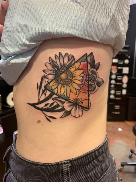 A Womans Stomach With A Sunflower And Triangle Tattoo On Her Side Ribcage
