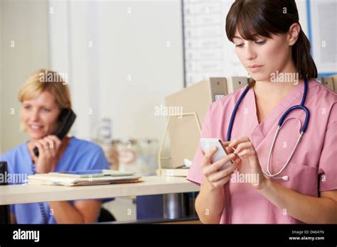 Two Nurses Discussing Patient Notes At Nurses Station Stock Photo Alamy
