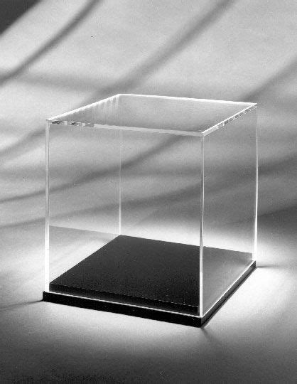 A Black And White Photo Of A Square Glass Box On A Table With Shadows