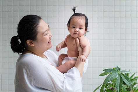 Asian Mother With Her Baby Girl In Home By Stocksy Contributor Bo Bo