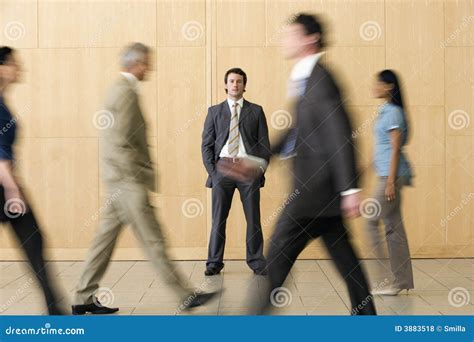 Confident Businessman With Team Walking Past Him Royalty Free Stock