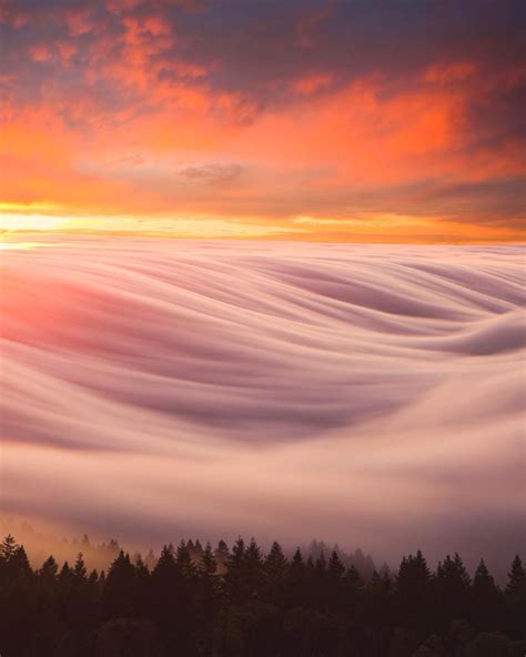 A Long Exposure Of Clouds Gently Rolling Over A Mountain Range R