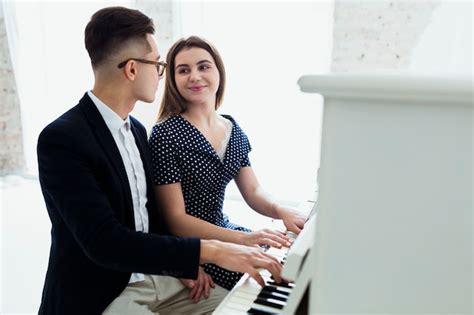 Un Séduisant Jeune Couple Jouant Du Piano En Se Regardant Photo Gratuite