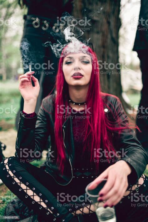 Beautiful Female Goth Smoking Cigarette And Drinking Alcohol In Park