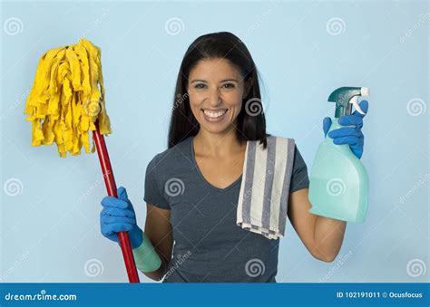 attractive hispanic woman happy proud as home or hotel maid cleaning and housekeeping holding