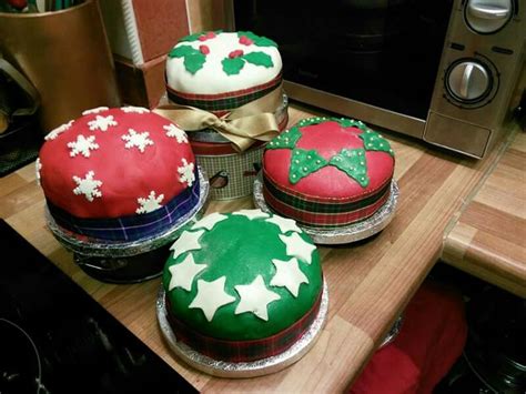 Four Decorated Cakes Sitting On Top Of A Wooden Table Next To A