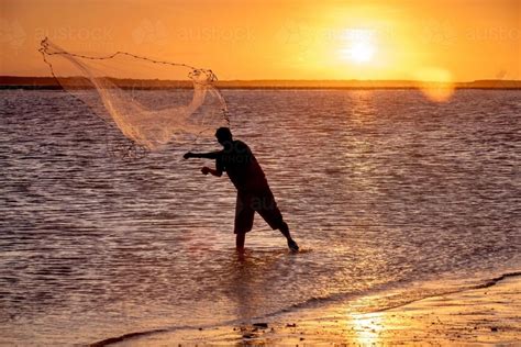 Image Of Fisherman Throwing A Cast Net At Sunset Austockphoto