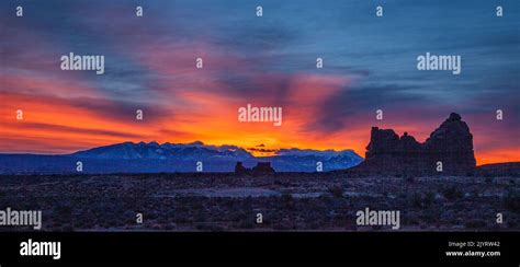 Colorful Sunrise Over The La Sal Mountains And A Sandstone Monolith As