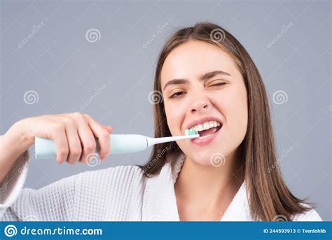 Beauty Portrait Of A Happy Beautiful Woman Brushing Her Teeth With A Electric Toothbrush