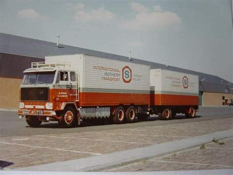 An Orange And White Truck Parked In Front Of A Building