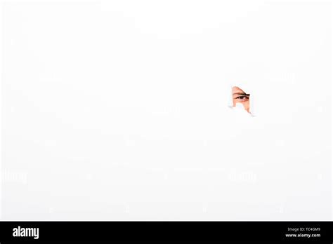 Man Looking Out From Hole In Paper Wall On White With Copy Space Stock
