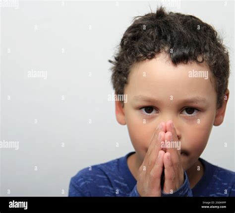 Niño Orando A Dios Con Los Ojos Cerrados Y Las Manos Juntas Foto De