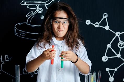 Asian American Female Child Scientist Holding Tube During A Experiment