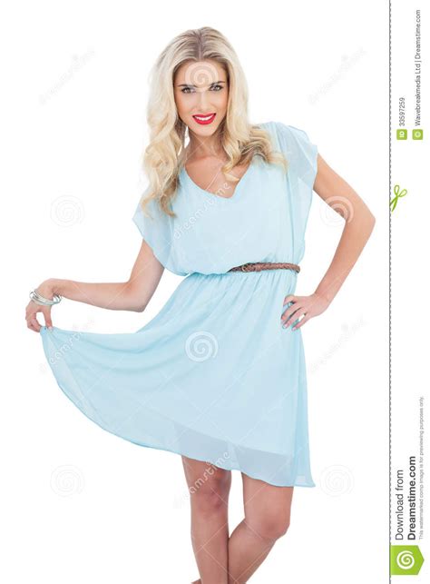Joyful Blonde Model In Blue Dress Posing Holding Her Dress Stock Image