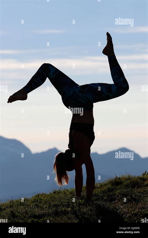 A Woman Performs A Hatha Yoga Pose On A Mountain Top Handstand With