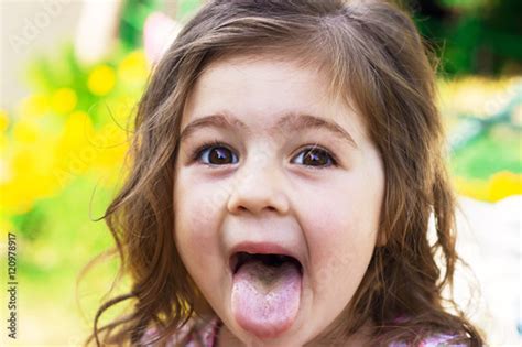 Portrait Of Cute Baby Girl With Tongue Sticking Out Stock Photo Adobe