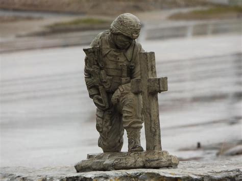 Soldier Kneeling At Cross Statue