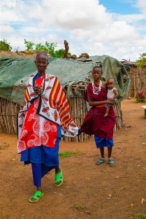 femmes de la tribu africaine maasai en robe nationale dans leurs maisons de village en argile