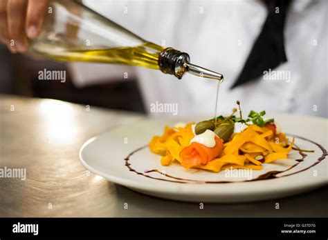 Chef Pouring Olive Oil On Meal Stock Photo Alamy